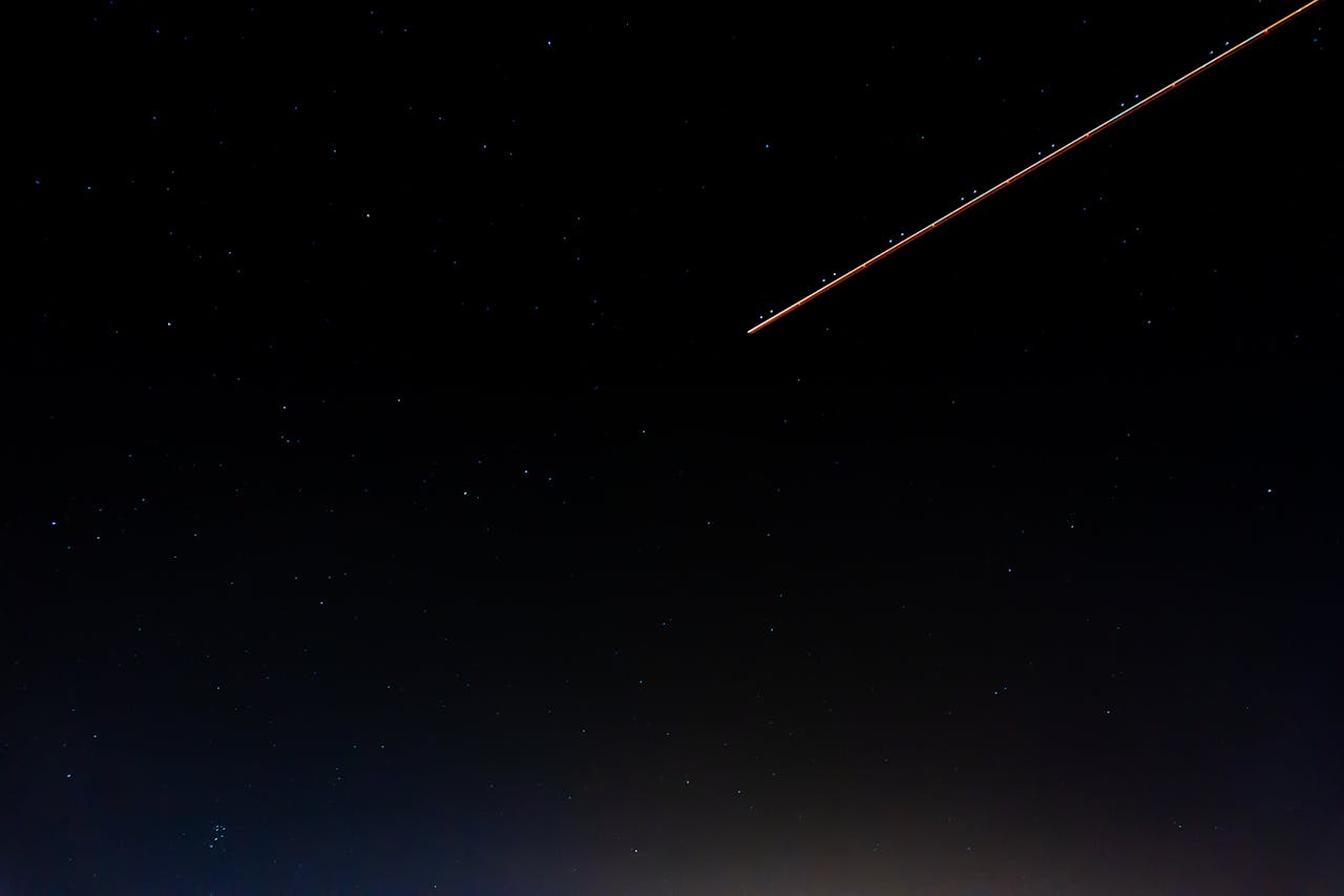 A serene night sky with a shooting star and numerous stars over Kénitra, Morocco.