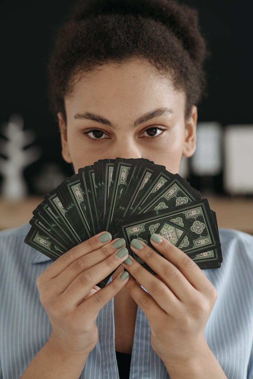 portrait of brunette woman holding tarot cards